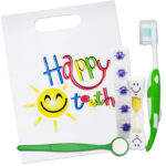 Children’s ‘Happy Teeth’ oral health gift set in a colourful bag with green toothbrush, yellow timer, green dental mirror and disclosing tablets.