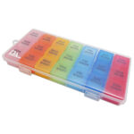 Clear plastic 21‑slot weekly pill organiser case with removable colour‑coded daily compartments and individual hinged lids for storing tablets and capsules.